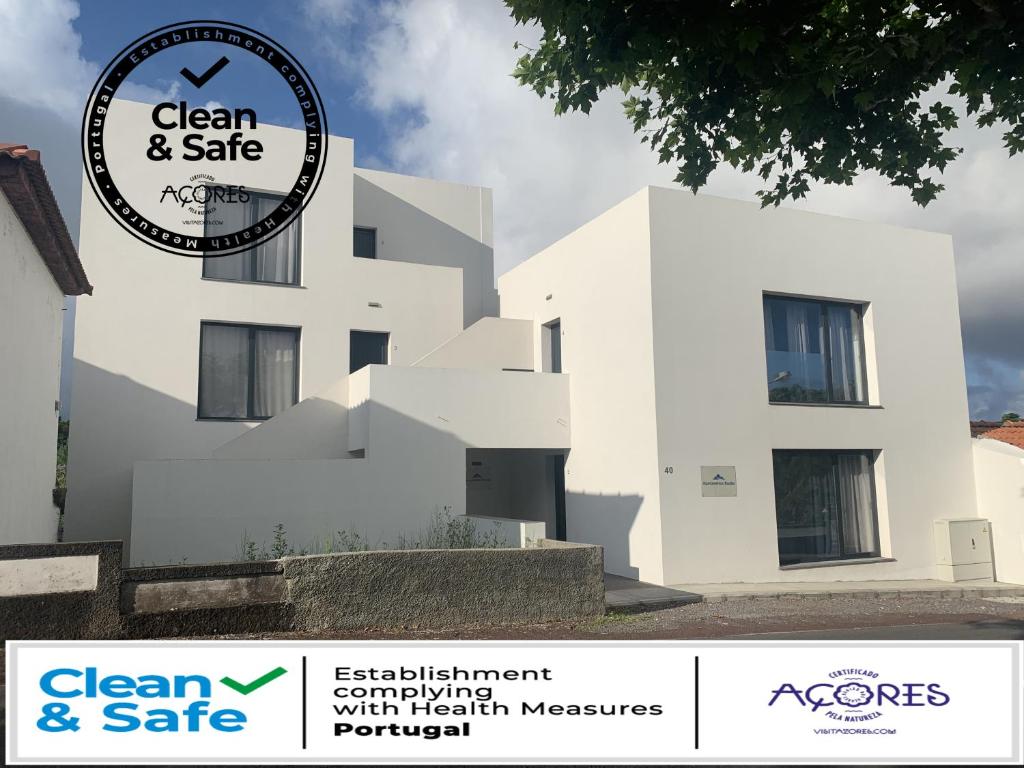 a white building with a sign for clean and safe at Apartamentos Basalto in Madalena