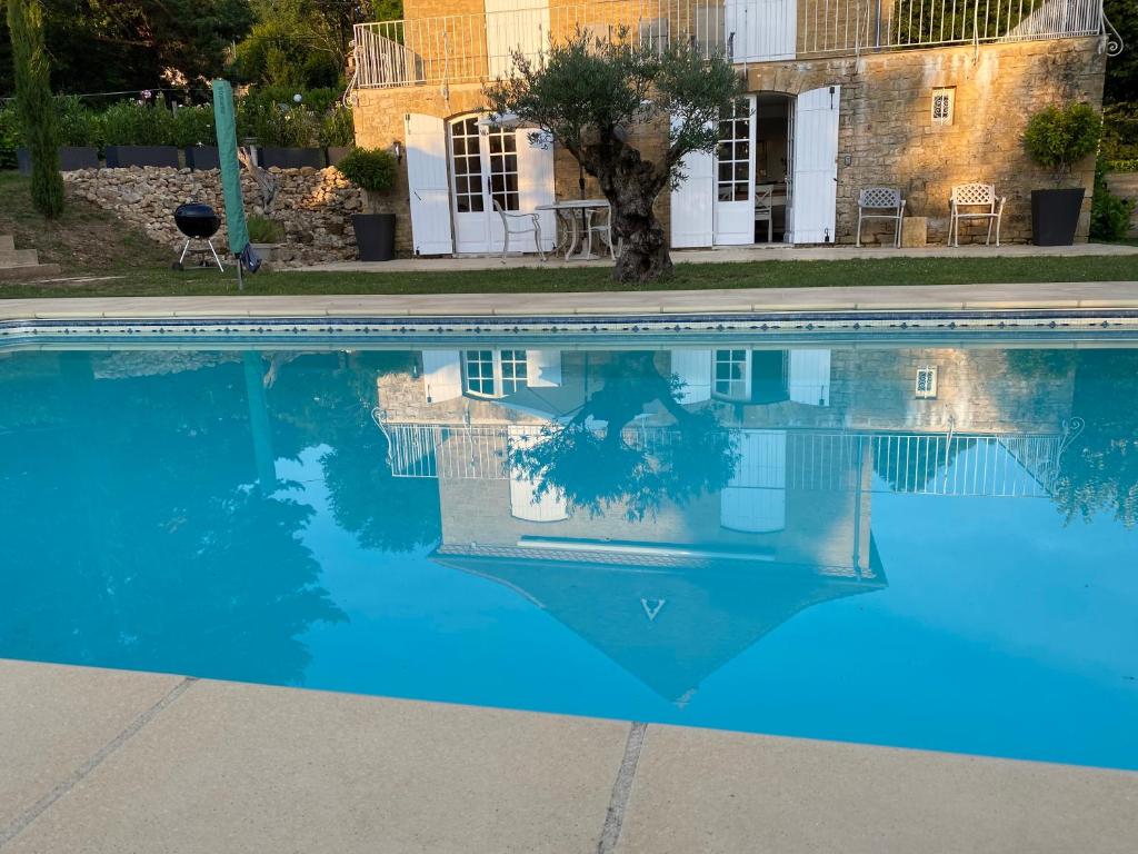 een zwembad met blauw water voor een gebouw bij Amity. Exclusive poolside garden apartment in Sarlat-la-Canéda