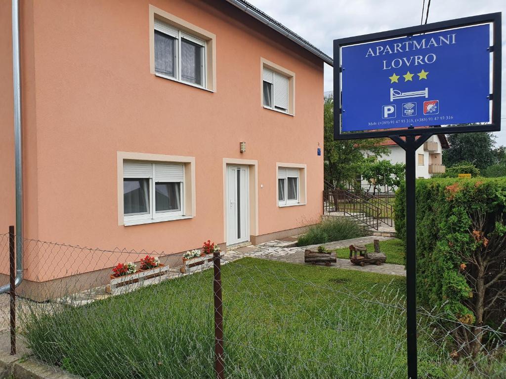 a blue sign in front of a house at Apartmani Lovro in Ogulin