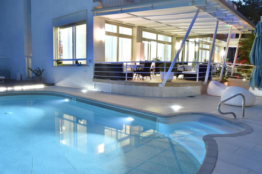 a swimming pool in front of a building at Hotel Meublè Nazionale in Lignano Sabbiadoro