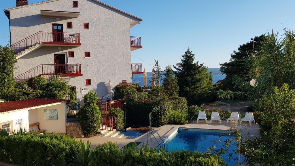 um edifício com piscina ao lado de uma casa em Apartment Katica em Crikvenica