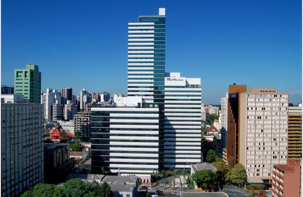 a view of a city with a tall building at Flat Anexo Ao Hotel Pestana in Curitiba