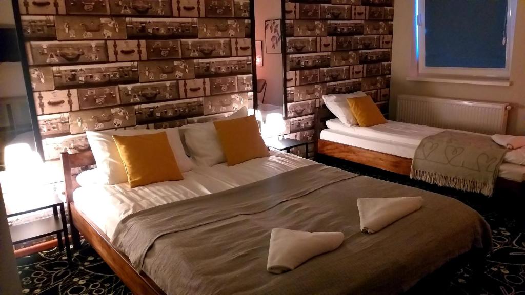1 Schlafzimmer mit 2 Betten und einer Wand mit Fotos in der Unterkunft Pensjonat Poranna Rosa in Grabowiec