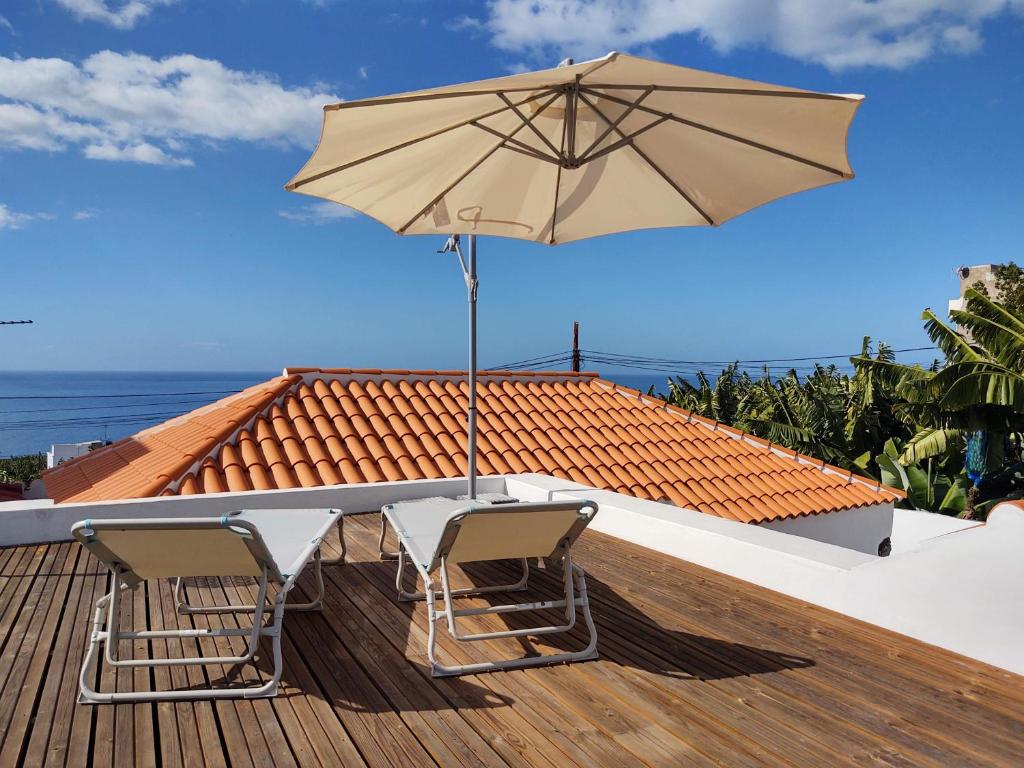 a table with two chairs and an umbrella on a deck at Casa Los Morros in Tazacorte