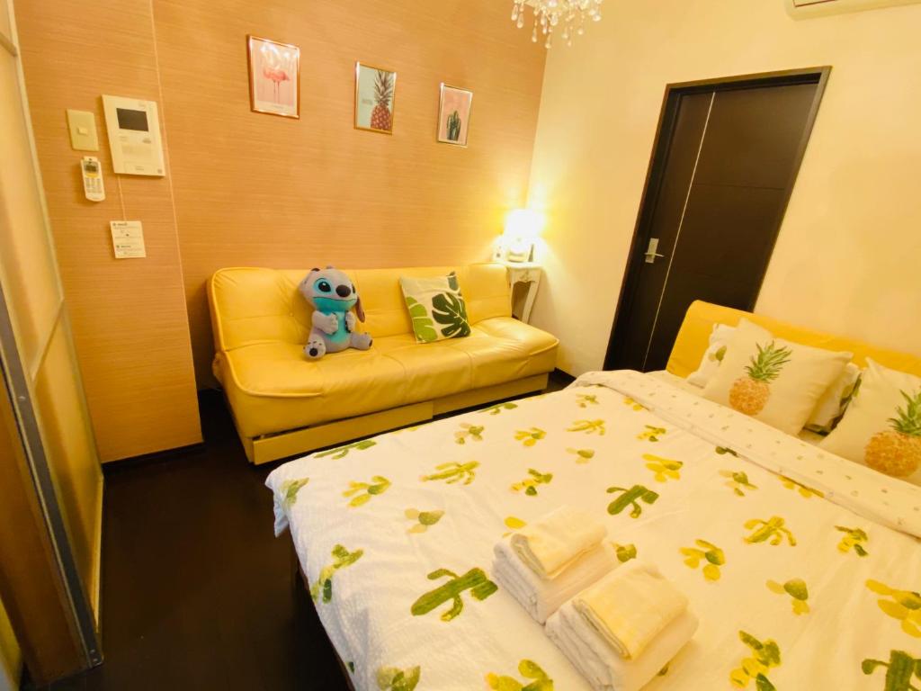 a room with two beds and a teddy bear sitting on a couch at Mori de house in kobe 102 in Kobe