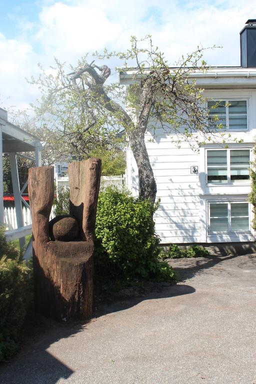 a statue of a cat sitting on top of a tree stump at Superior Citycottage Kristiansand in Kristiansand