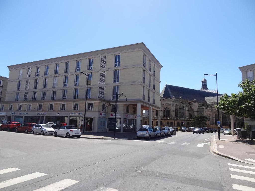 un edificio en una calle con coches aparcados delante en Studio L'AZULEJOS, en Le Havre