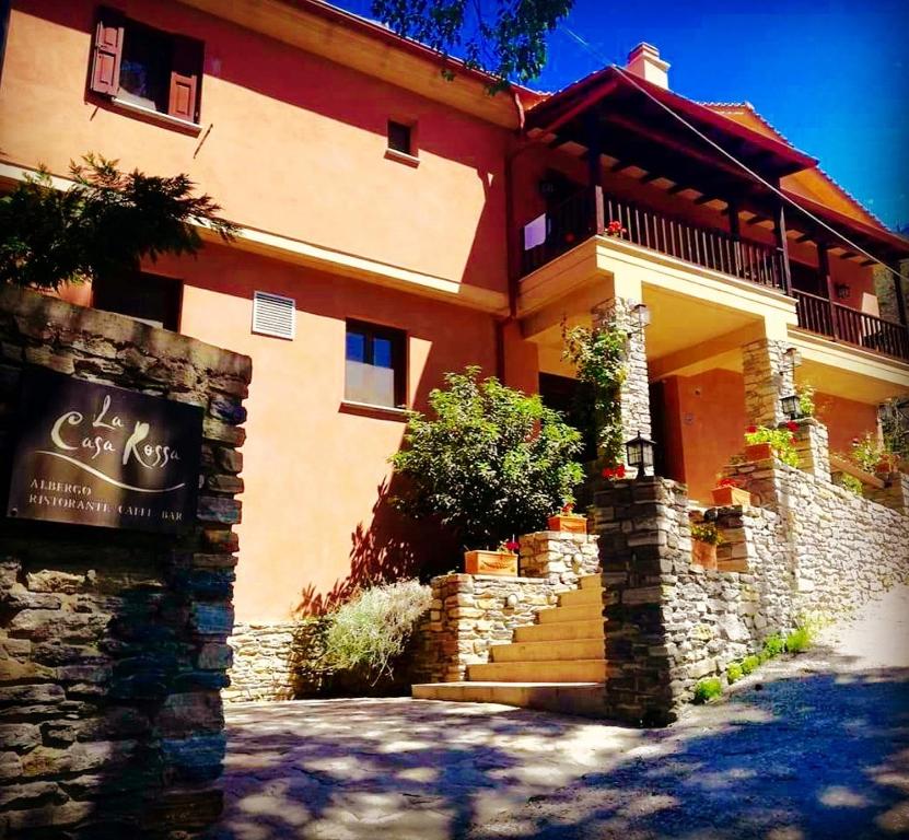 a building with a staircase in front of it at La Casa Rossa in Prinos