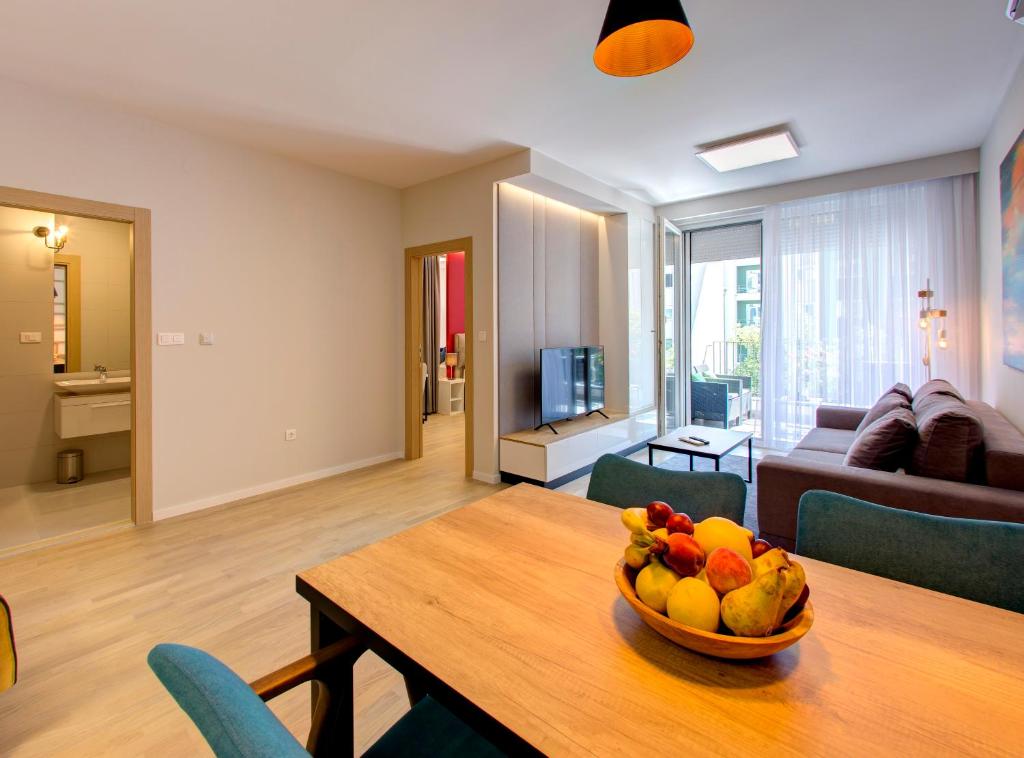 uma taça de fruta numa mesa de madeira na sala de estar em Luxury apartment Concept em Mostar