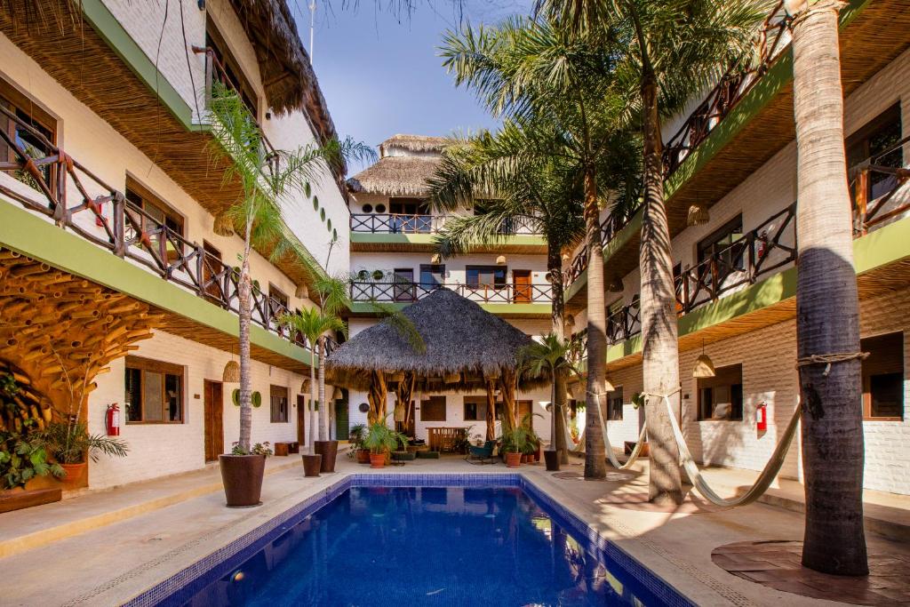 un patio con piscina en un edificio con palmeras en Selina Sayulita, en Sayulita