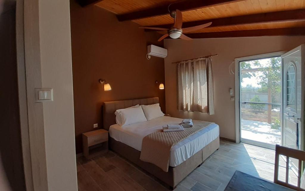 Room near the Airport في Pikérmion: غرفة نوم بسرير ومروحة سقف