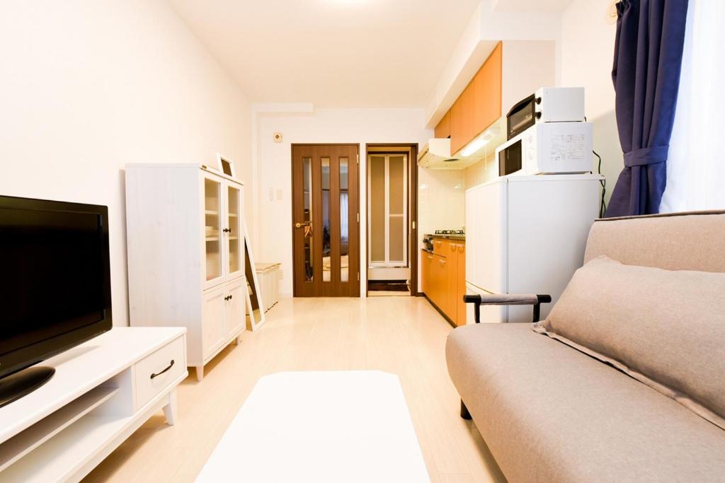 - un salon avec un canapé et une télévision dans l'établissement Northwest IR Room 201 - Vacation STAY 8477, à Sapporo