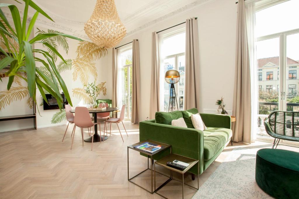 a living room with a green couch and a table at La Paulowna Boutique Hotel in The Hague