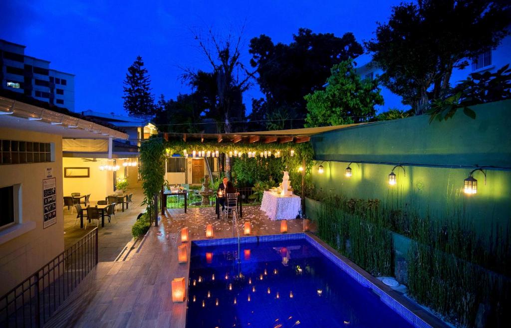 a backyard with a swimming pool at night at Las Magnolias Hotel Boutique in San Salvador