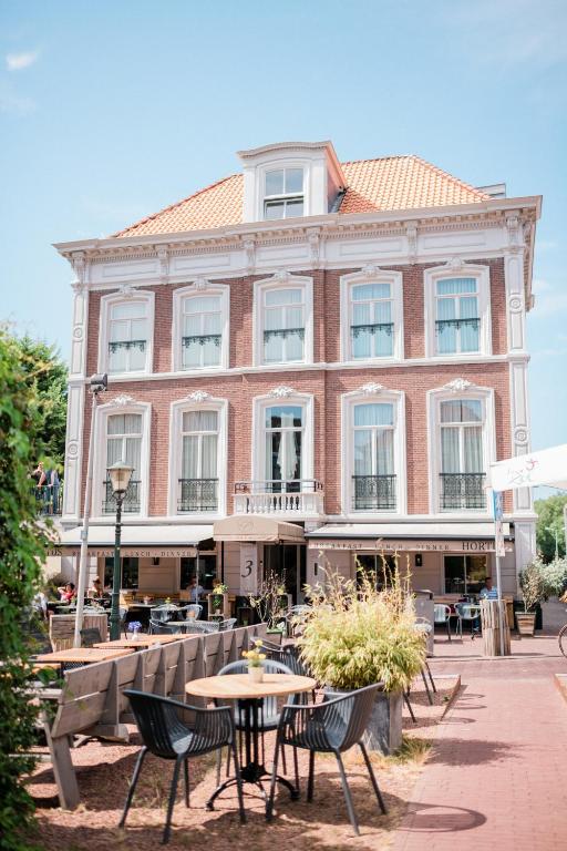 een gebouw met tafels en stoelen ervoor bij La Paulowna Boutique Hotel in Den Haag