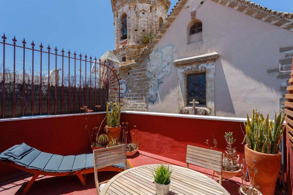 eine Terrasse mit 2 Stühlen, einem Tisch und einem Gebäude in der Unterkunft Atico de los FRANCESES by Cadiz4Rentals in Cádiz