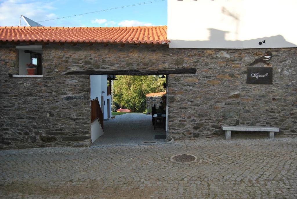 una entrada a un edificio de piedra con un banco en la parte delantera en Alformil, en Bragança