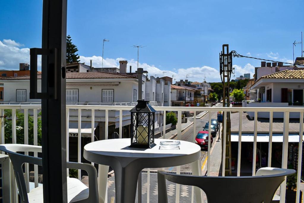 una mesa y sillas en un balcón con una calle en Nice apartment in the center of Can Picafort, en Can Picafort