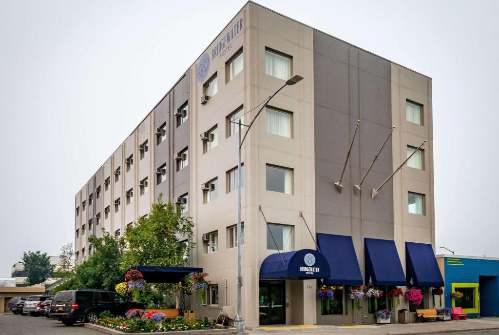 a large white building with blue awnings on it at Bridgewater Hotel, Trademark Collection by Wyndham in Fairbanks