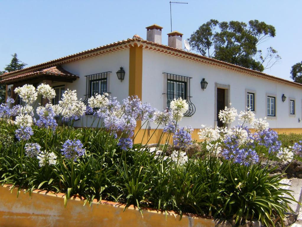 a house with flowers in front of it at Quinta Da Torre - Óbidos Country House in Óbidos