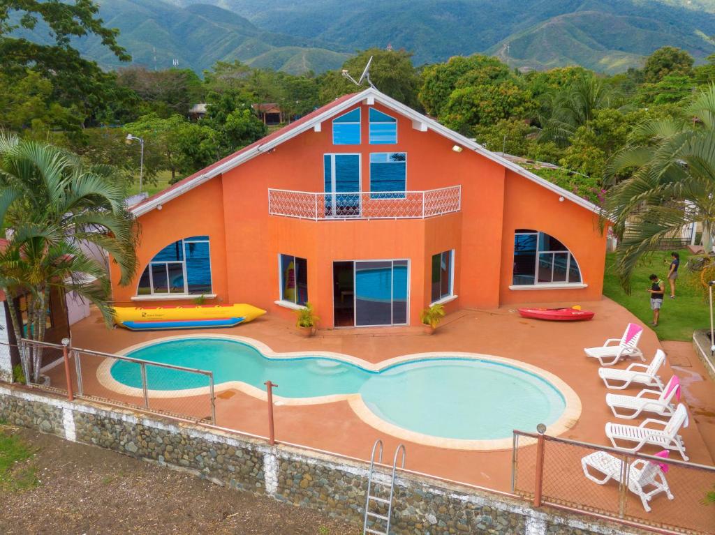 an orange house with a pool in front of it at Chalet Castillo in El Estor