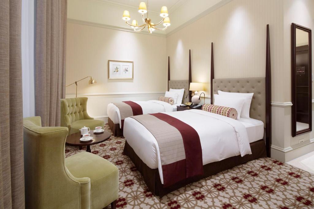 a hotel room with two beds and a chair at The Tokyo Station Hotel in Tokyo