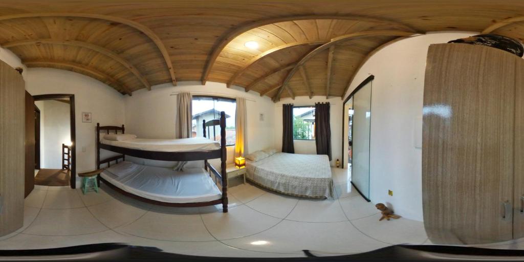 1 dormitorio con 1 cama en una habitación con techo de madera en Pousada Bem te vi en Garopaba