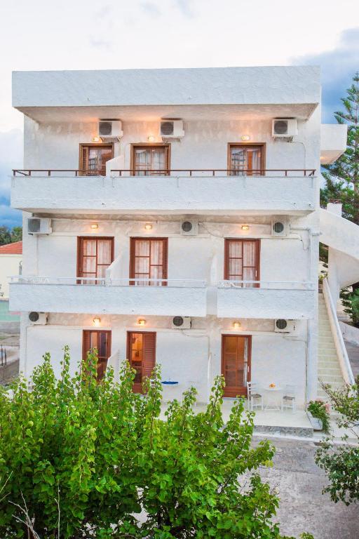 a white building with trees in front of it at Filoxenia Studios 1 in Palaiochora