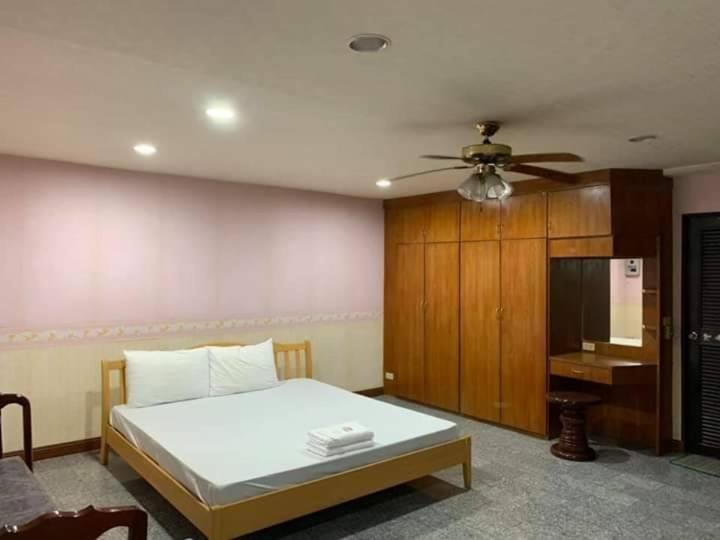 a bedroom with a bed and a ceiling fan at โชคชัยแมนชั่น บางบัวทอง in Nonthaburi