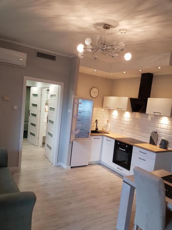 a kitchen with white cabinets and a ceiling at Apartament Polonia in Kołobrzeg