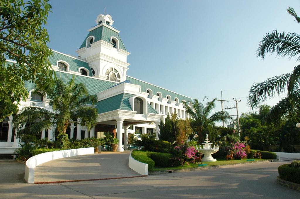 a large white building with a green roof at The Camelot Hotel Pattaya in Pattaya South