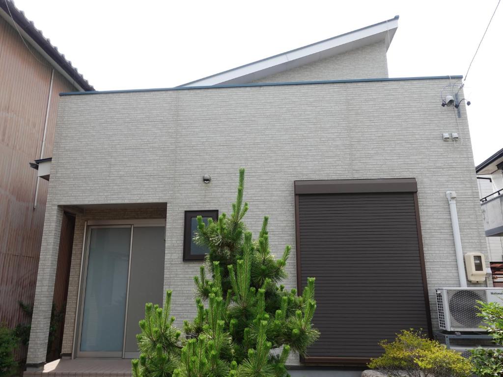 桑名市にあるmachiyado Kuwanajuku Honmachi 10の黒いガレージのある灰色のレンガ造りの家