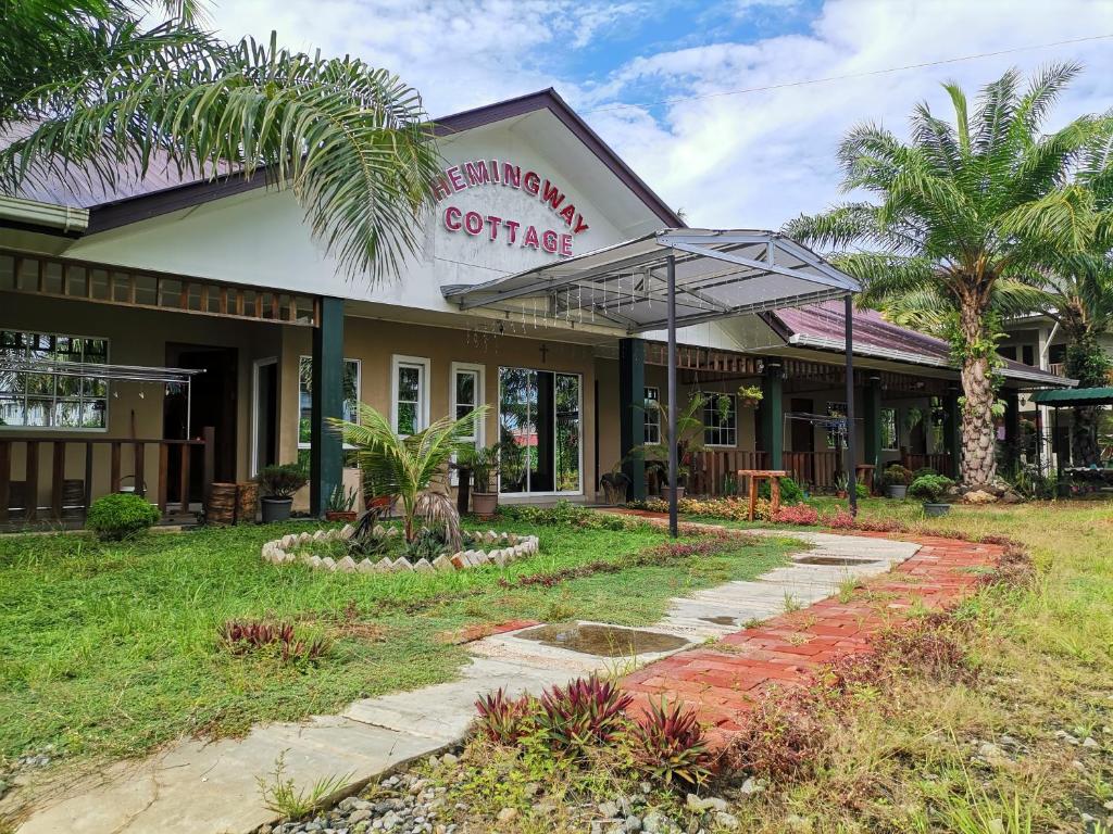 a building with an umbrella in front of it at Hemingway Cottage 海明威度假屋 in Semporna
