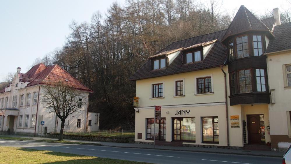 un grand bâtiment blanc sur le côté d'une rue dans l'établissement Penzion Jany, à Luhačovice