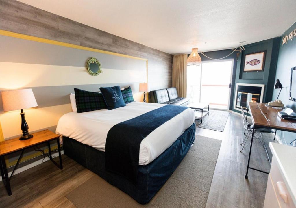 a bedroom with a large bed and a living room at Surftides Hotel in Lincoln City