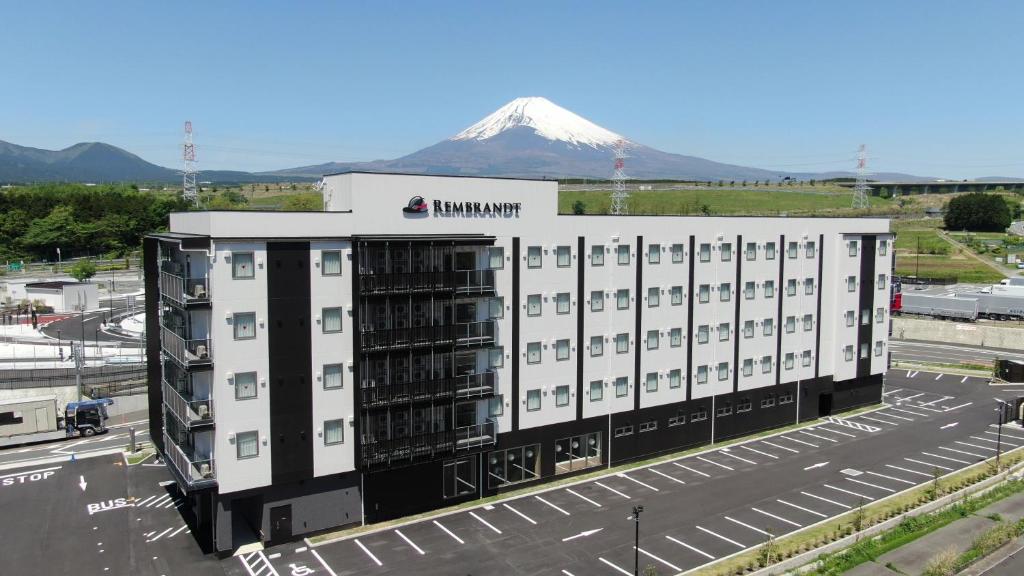 a large white building with a mountain in the background at Rembrandt Style Gotemba Komakado in Gotemba