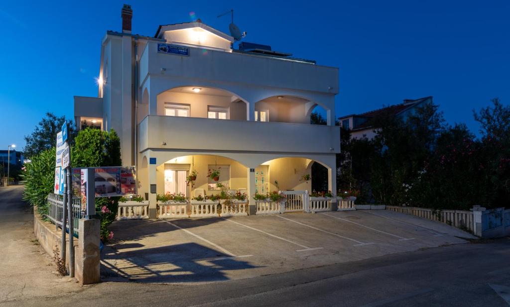 un edificio con un estacionamiento delante de él en Apartments Villa Filip, en Trogir
