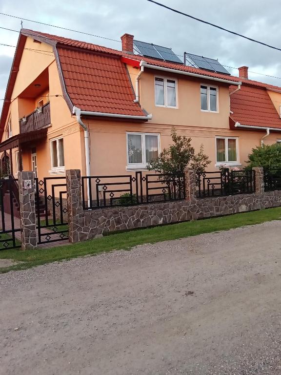 a house with a fence in front of it at Timi Kulcsosház in Lăzarea