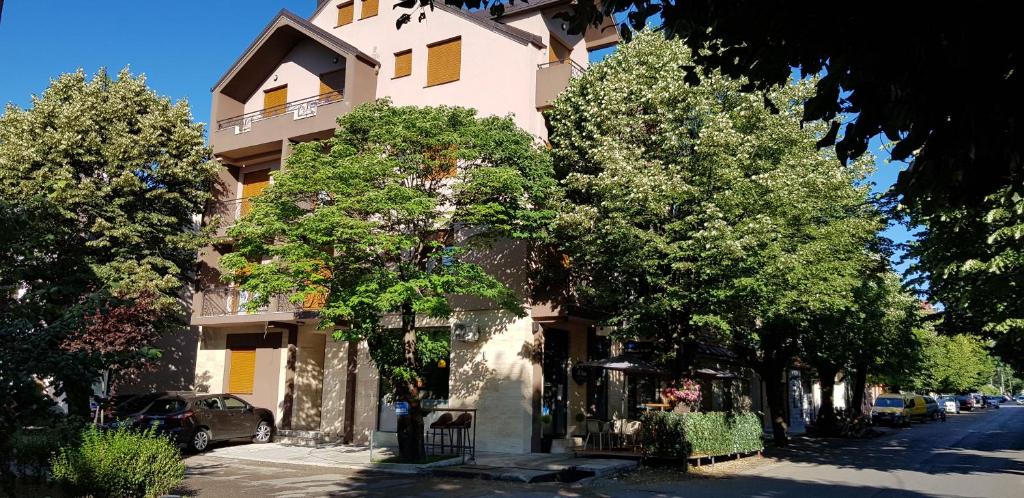 a building on a street with trees in front of it at apartmani Daria in Cetinje