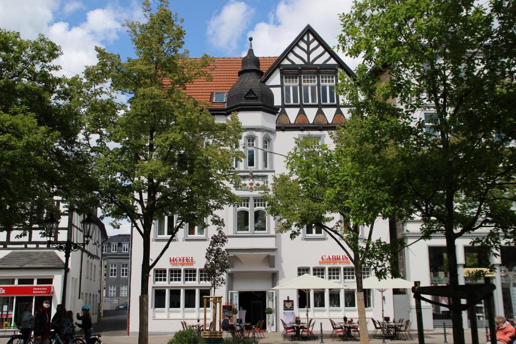 ein großes weißes Gebäude mit schwarzem Dach in der Unterkunft Hotel Drei Kronen in Lippstadt