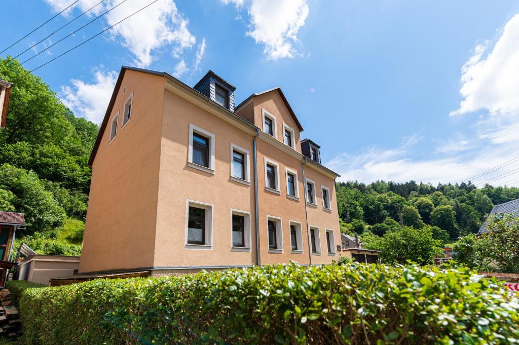 um grande edifício castanho com árvores ao fundo em Haus am Malerweg em Bad Schandau