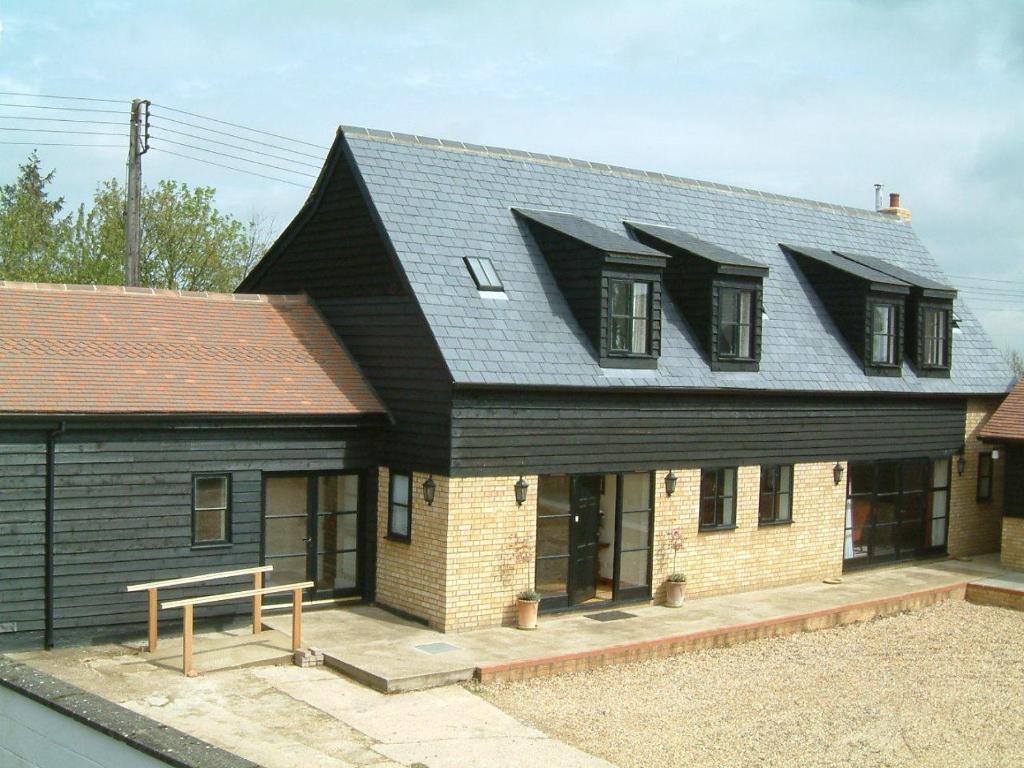 a house with a black roof on top of it at Highfield Farm in Sandy