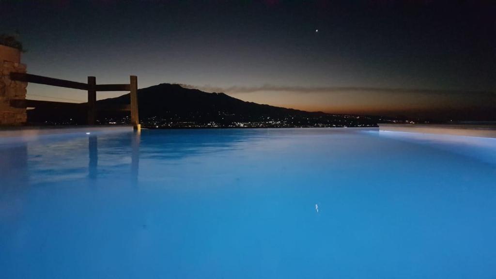 una gran piscina con una valla y una montaña en Balcone sull'Etna Casa Biondi, en Centuripe