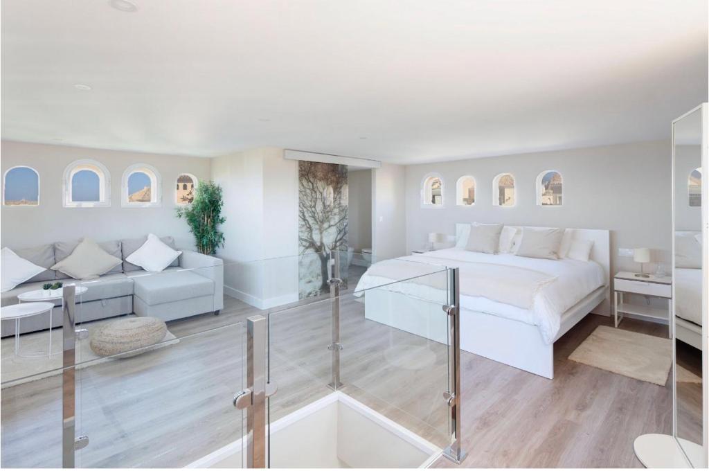 a white bedroom with a bed and a couch at AMAZING DUPLEX NEXT TO THE BEACH IN MARBELLA in Marbella