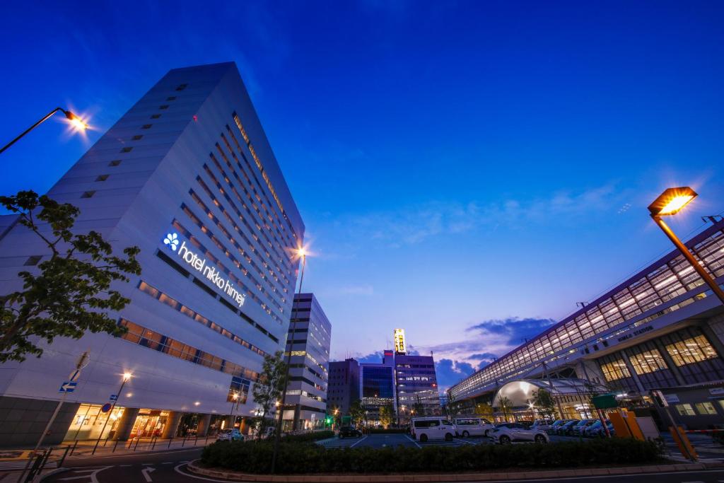 a city street with tall buildings at night at Hotel Nikko Himeji in Himeji