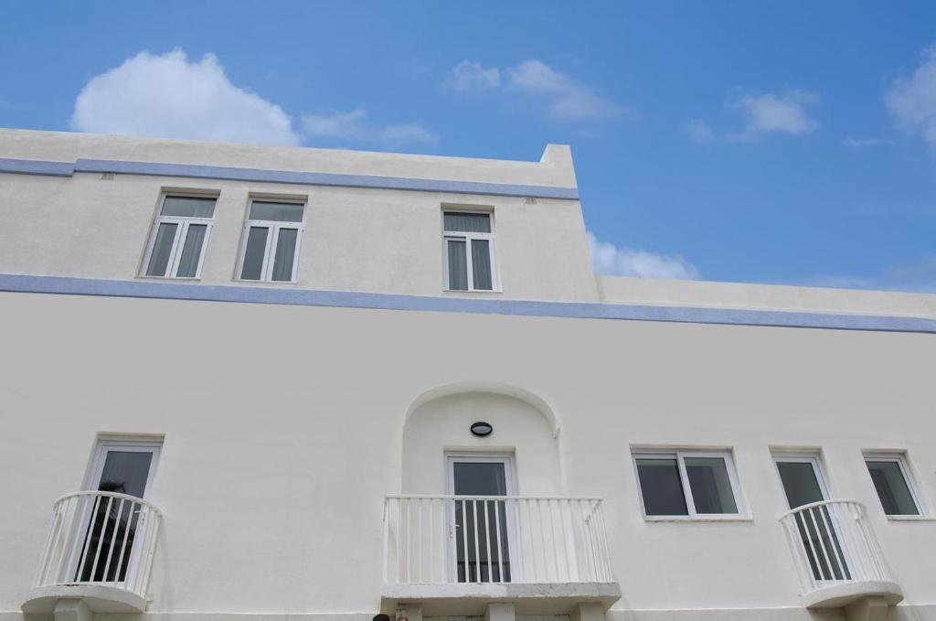 a white building with balconies on the side of it at Cresta Beach Studios in St. Julianʼs