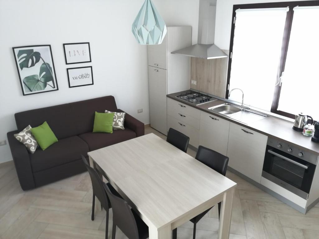 sala de estar con mesa y sofá en Appartamento Monte Granatico 02, en SantʼAntìoco