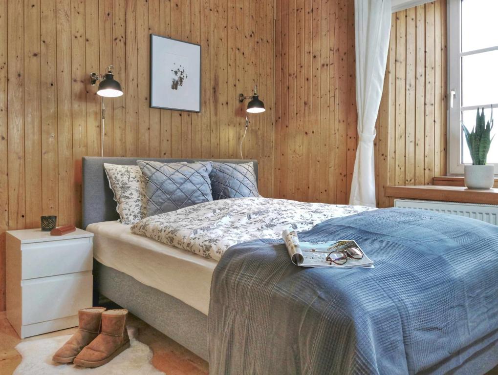 a bedroom with a bed and a wooden wall at Ferienwohnung Himmelberg 80m2 in der Altstadt und toll für Familien in Klagenfurt