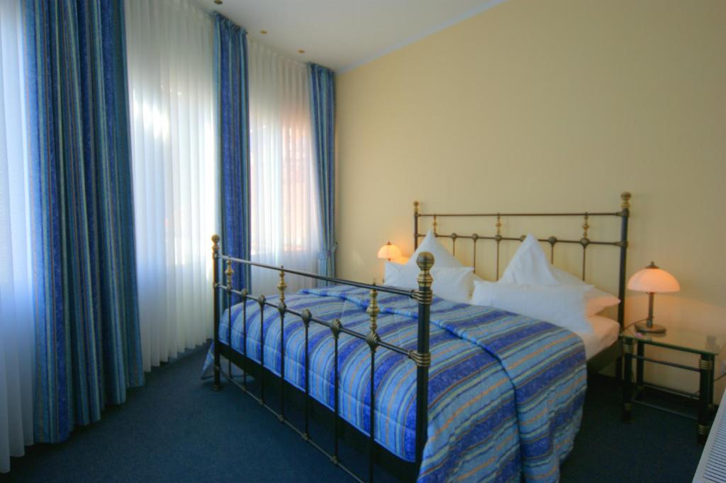 Postel nebo postele na pokoji v ubytování KurparkHotel Warnemünde
