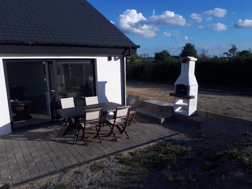 eine Terrasse mit einem Tisch, Stühlen und einem Kamin in der Unterkunft Lacs de l'eau d'heure VINEUF in Erpion